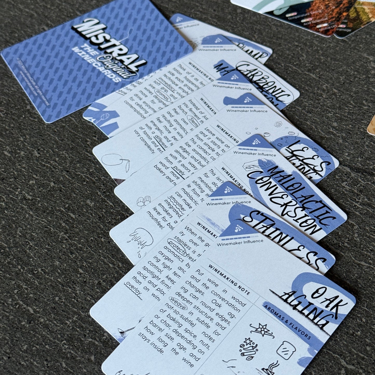 Collection of branded Mistral Winemaking WineCards on a dark surface