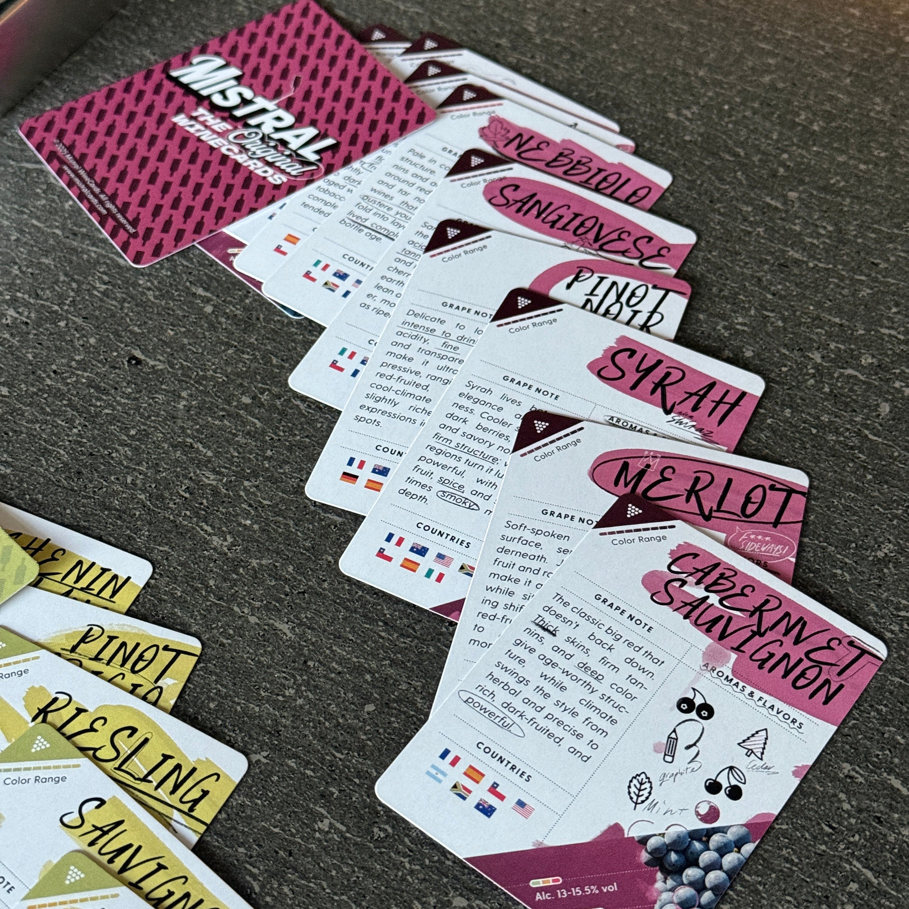 Set of Mistral WineCards Grape playing cards with various designs and text on a dark surface