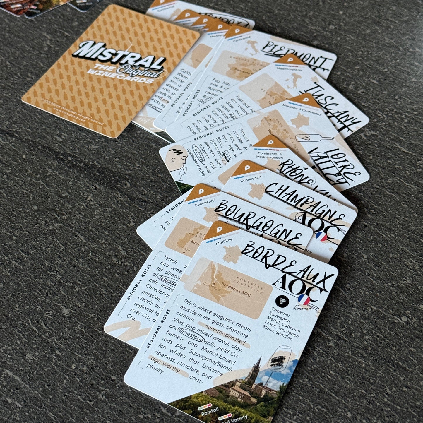 Collection of Region-themed Mistral WineCards on a textured surface