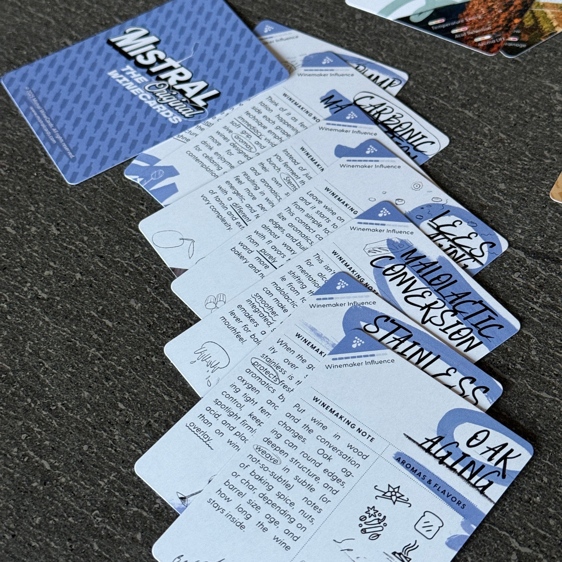 Collection of branded Mistral  Winemaking WineCards on a dark surface