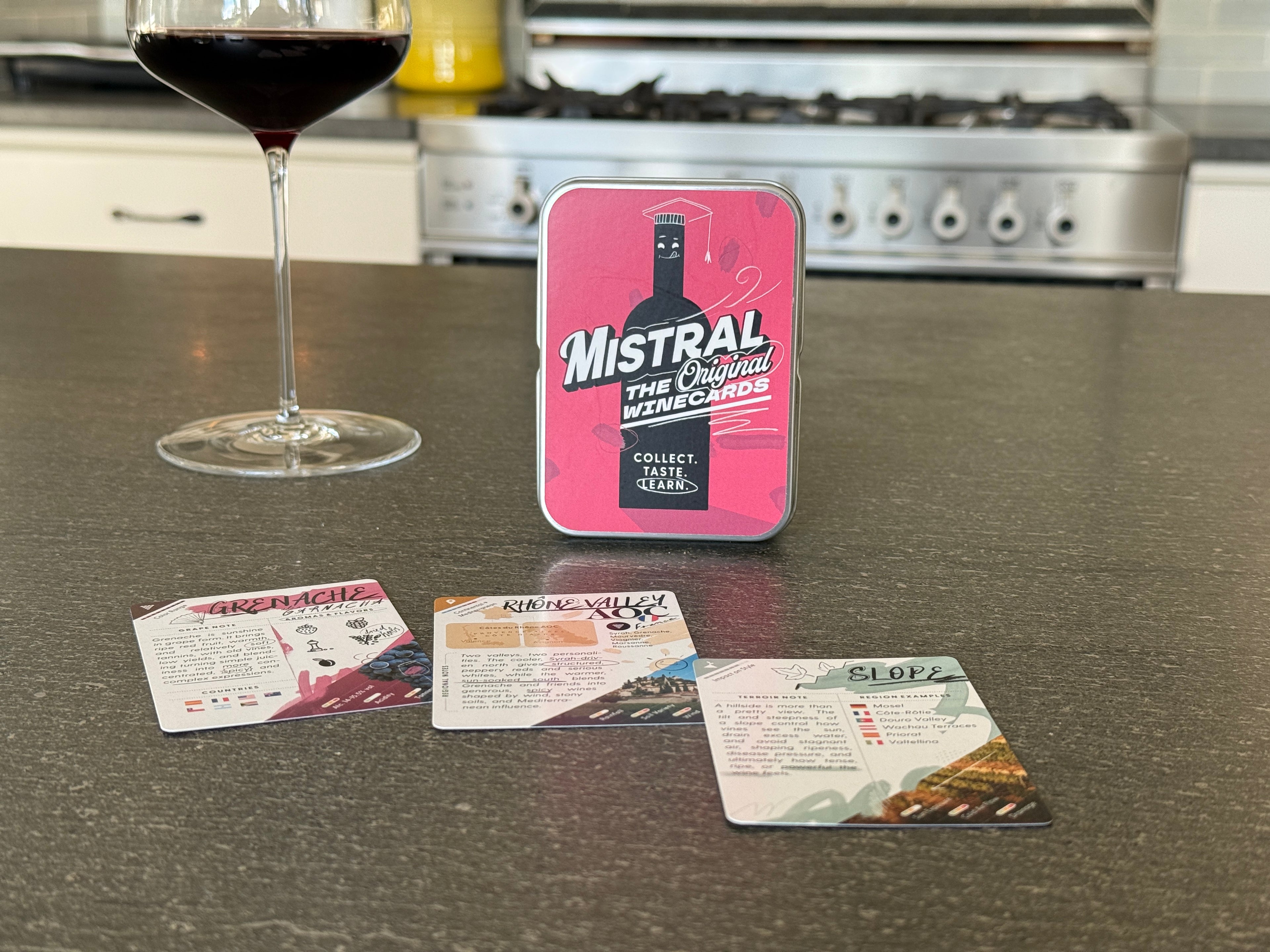 Mistral WineCards tin with wine glass and cards on a kitchen counter